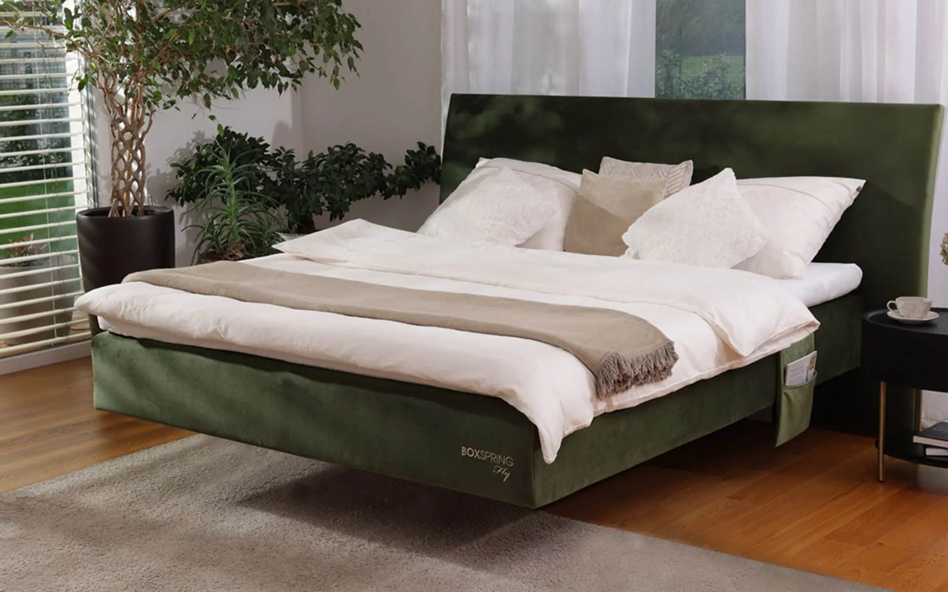 Zelena lebdeča BoxSpring postelja podjetja Maremico v svetli spalnici
